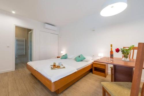 a bedroom with a bed and a desk and a table at Villa Sarah in Lopud Island