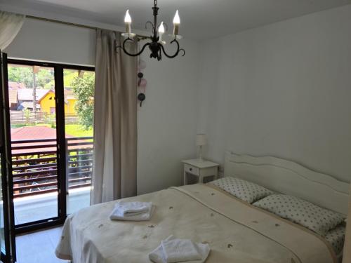 a bedroom with a bed and a large window at Casa Artemis-jacuzzi și piscină in Pianu de Sus