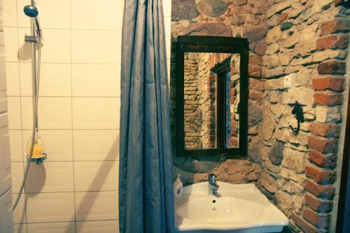 a bathroom with a sink and a stone wall at House of Hops in Pamarnakai