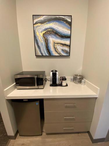 a desk with a microwave and a painting on the wall at Best Western Premier Prince Albert in Prince Albert