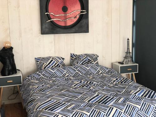 une chambre avec un lit et une horloge au mur dans l'établissement Le Petit Caillebotis, à La Rochelle