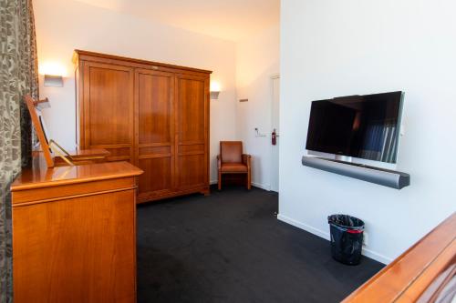 a hotel room with a flat screen tv on the wall at Hotel La Rosa Amsterdam Beach in Zandvoort