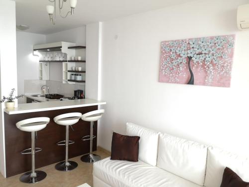 a living room with a white couch and a kitchen at Villa Eros Apartments in Struga