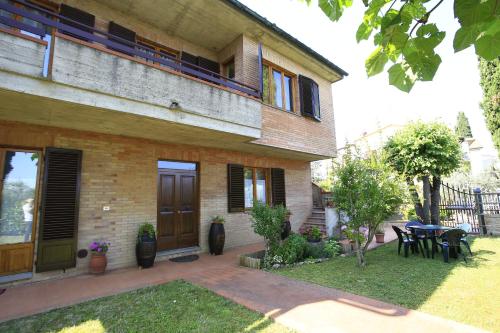 a house with a patio and a table in front of it at Casa Milena in San Gimignano