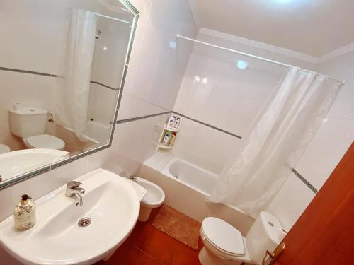 een badkamer met een wastafel, een toilet en een spiegel bij Apartamento de 3 habitaciones, zona muy tranquila a unos minutos de la playa in Mazagón