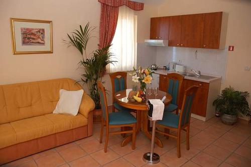 a living room with a couch and a table and a kitchen at ApartHotel Villa Mozart in Podgora