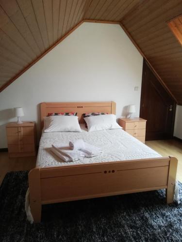 a bedroom with a large bed with white sheets at casa cardeal saraiva in Ponte de Lima