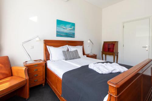 a bedroom with a bed and a chair at Hotel La Rosa Amsterdam Beach in Zandvoort