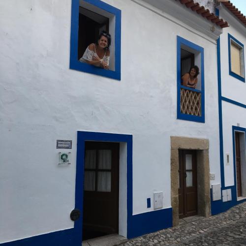a woman looks out of a window of a house at Casas De Romaria in Brotas