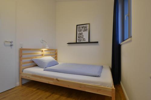 a bedroom with a bed with blue sheets and a window at Townside Hostel Bremen in Bremen
