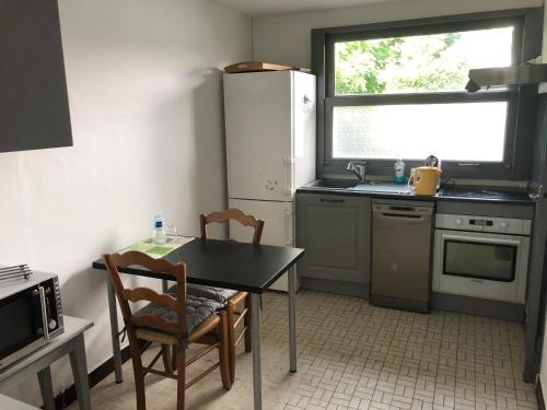 une cuisine avec une table et deux chaises ainsi qu'une fenêtre dans l'établissement Villa des T, à Arcachon