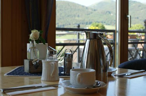 a table with a tea kettle and a cup on it at Hotel Weissenstein in Sankt Michael im Lungau