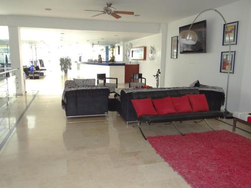a living room with a black couch and red pillows at Atlantis Plaza Hotel Cúcuta in Cúcuta