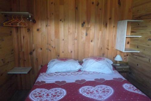 um quarto com uma cama com duas almofadas brancas em Petit chalet de montagne em Saint-Nectaire