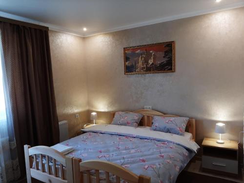 1 dormitorio con 1 cama con sábanas azules y 2 sillas en Park Hotel en Umanʼ