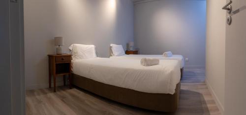 ein Schlafzimmer mit einem großen Bett mit weißen Laken und Kissen in der Unterkunft MainStreet, VintageGroup in Espinho