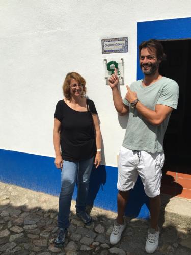 a man and a woman standing in front of a basketball hoop at Casas De Romaria in Brotas