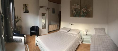Schlafzimmer mit einem weißen Bett und einem Spiegel in der Unterkunft B&B Aarsabroch in Brügge