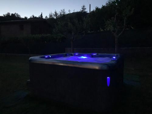 a hot tub with blue lights in a yard at night at Nidi del faggio rosso - Family Holiday Home in Maresca
