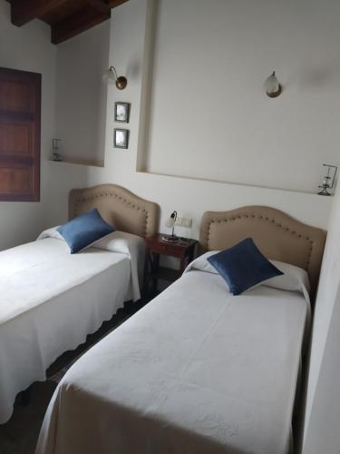 two beds with blue pillows in a room at Casa Collao 24 in Sierra