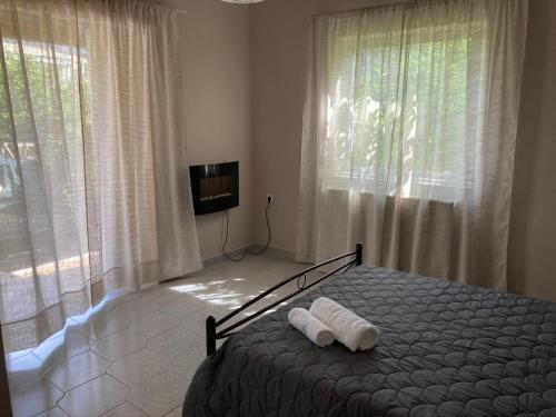 ein Schlafzimmer mit einem Bett mit zwei Handtüchern darauf in der Unterkunft Elegant house by the sea with pool in Akráta