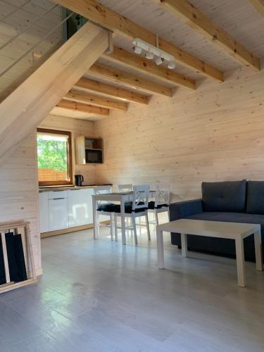 ein Wohnzimmer mit einem blauen Sofa und einem Tisch in der Unterkunft Del sol in Pogorzelica