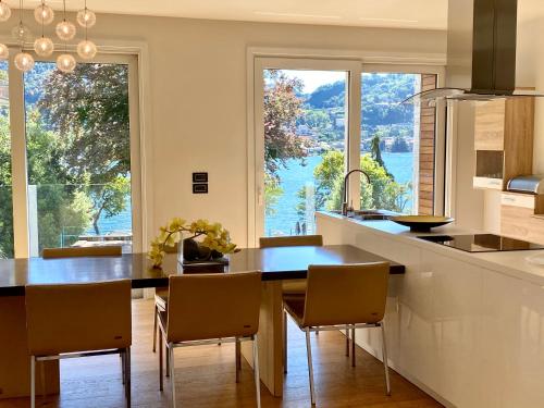 a kitchen with a table and chairs and a large window at Villa Bianca in Como
