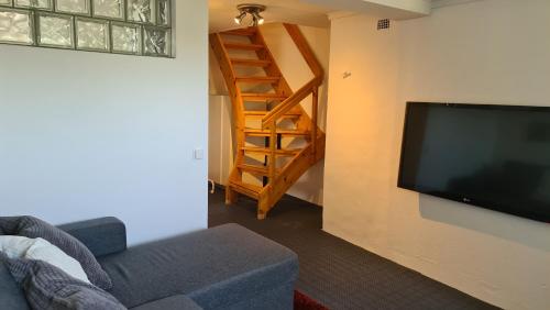 a living room with a couch and a flat screen tv at Symaskinshuset Järvsö in Järvsö