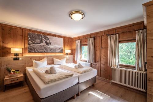 - 2 lits dans une chambre dotée de murs en bois dans l'établissement Ferienhäuser Mayrhofen, à Mayrhofen