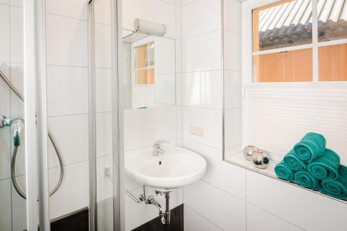 a white bathroom with a sink and a mirror at Leonhardsblick Appartements in Tamsweg