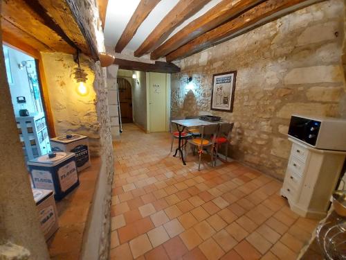 une cuisine avec une table dans un mur en pierre dans l'établissement Gîte Au près du Lys, à Saint-Martin-le-Beau