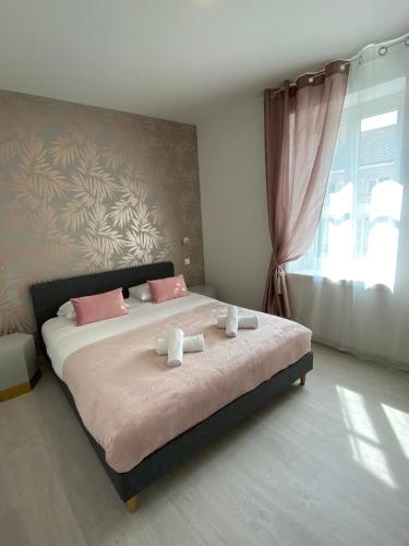 une chambre avec un lit avec deux serviettes dessus dans l'établissement Le Nid du Faubourg, à Beaune