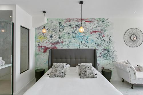 - une chambre avec un grand lit blanc et un mur dans l'établissement Village Naturiste - Le Diamond X Héliopolis Luxe, au Cap d'Agde