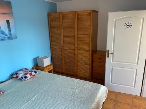 a bedroom with a bed and a wooden cabinet at Apartman Delfin in Senec