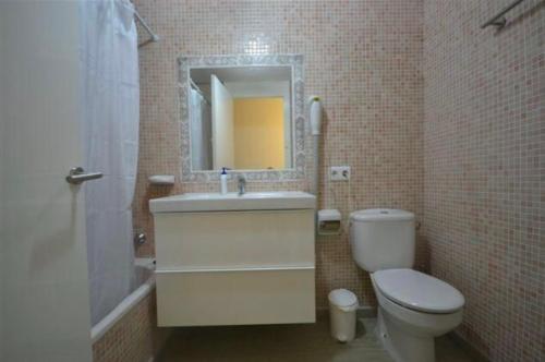 a bathroom with a toilet and a sink and a mirror at Stupendo Appartamento a Cala’n Bosch Minorca in Cala'n Bosch