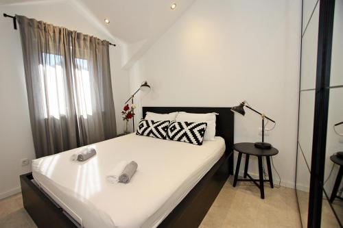 een slaapkamer met een groot wit bed en een lamp bij Apartman Gajka in Supetar