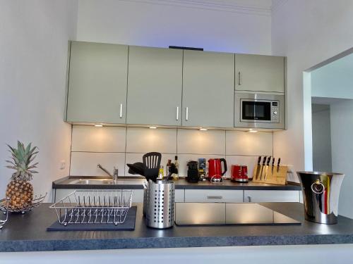 a kitchen with white cabinets and a counter top at Chez Coco Apartment 2 Aachen in Aachen