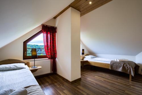Schlafzimmer im Dachgeschoss mit 2 Betten und einem Fenster in der Unterkunft Apartamenty na Pienińskim Wzgórzu in Szczawnica