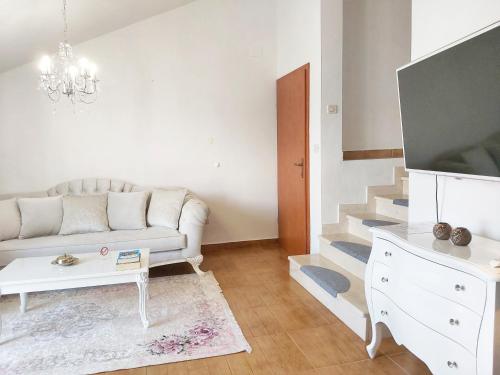 a living room with a white couch and a tv at Adria Apartments and Rooms in Dubrovnik