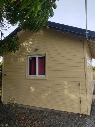 a small yellow garage with a window at chez rodrigue in Petit-Canal
