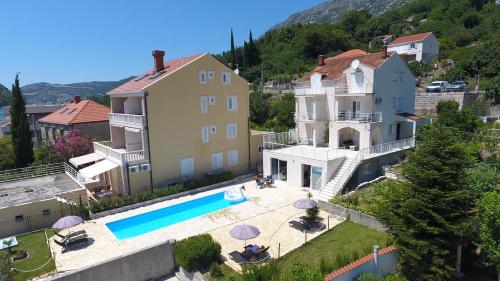 - une vue aérienne sur une maison et une piscine dans l'établissement Apartments Pralas, à Mokošica