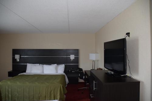 a hotel room with a bed and a flat screen tv at Rodeway Inn Festival in Stratford