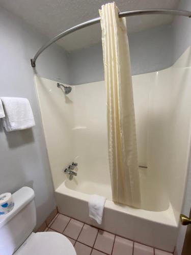 a bathroom with a white toilet and a shower at Colonial Inn in Shawnee