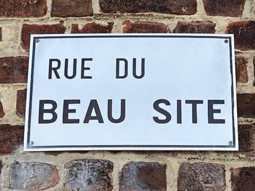 a sign on a brick wall with the wordsrue du beau site at Zen Retreat met jacuzzi in Grez-Doiceau