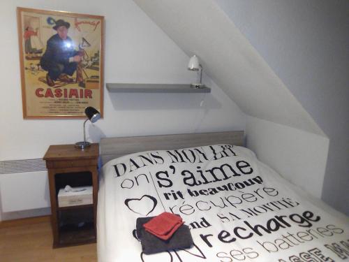 une chambre avec un lit et un panneau sur le mur dans l'établissement ART APPART KEMPER, à Quimper