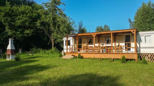 una casa de madera en un campo con patio en Domki Nad Jeziorem "Półwysep SURYTY", en Suryty