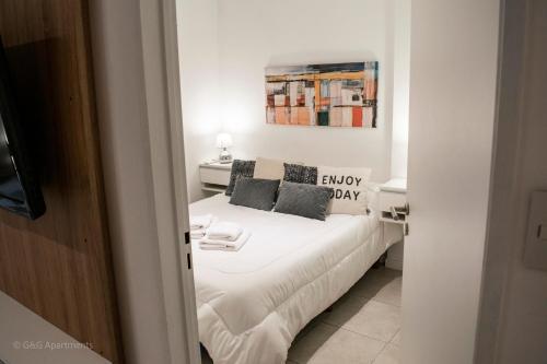 1 dormitorio con 1 cama con sábanas y almohadas blancas en G&G Apartments - Obelisco Perfect location en Buenos Aires