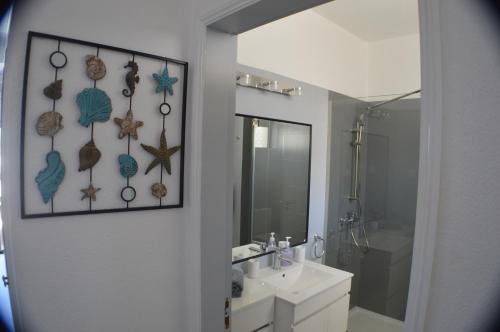 a bathroom with a sink and a mirror at Joli studio rénové Emplacement idéal front de mer in Cabanas de Tavira