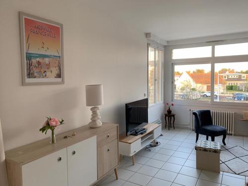 sala de estar con escritorio, TV y ventana en Les Alisés, en Merville-Franceville-Plage