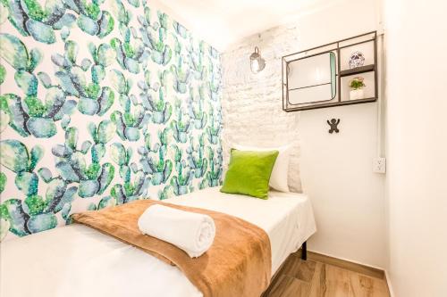 a small bedroom with a green pillow on a bed at Casa Kanabri Hostal Boutique in Mexico City